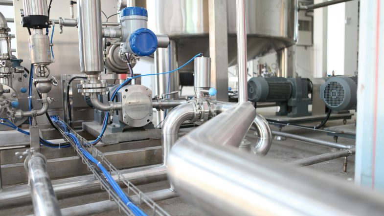 Impianto di processo in acciaio inox con pompe, valvole e tubazioni